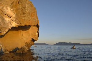 Sea kayaking under sculpted sandstone cliffs by Kevin Oke