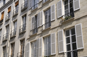 Apartment windows with open shutters and balconies - Paris by Kevin Oke