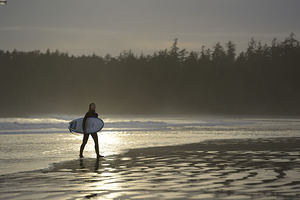 Women walking with a surfboard on Long Beach Pacific Rim National Park