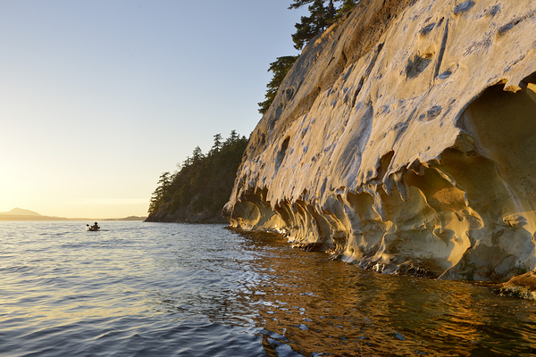 Sea kayaking under the sculpted sandstone cliffs Print