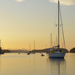 Sea kayaker and anchored boats in Princess Bay