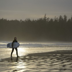 Women walking with a surfboard on Long Beach Pacific Rim National Park