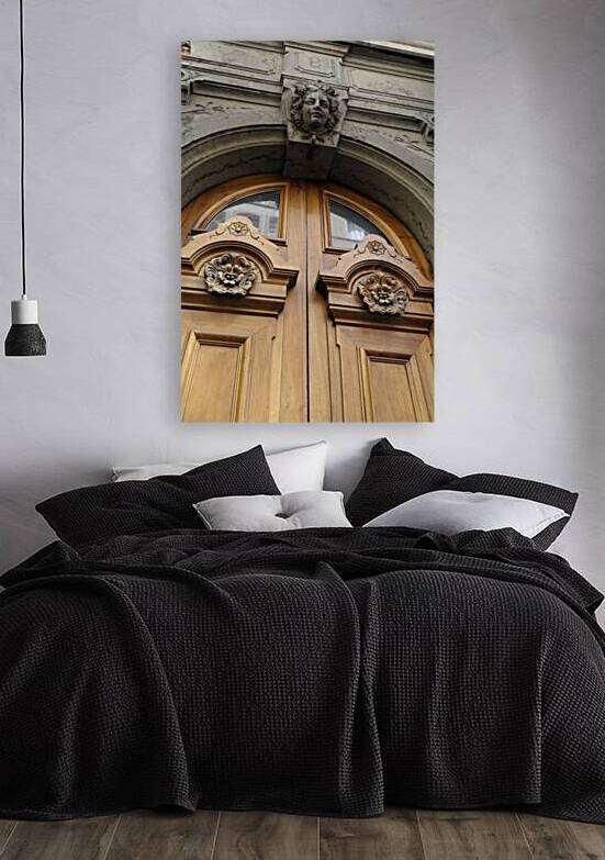 Wooden door with carved figurine in stone above it. France by Kevin Oke